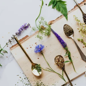 A wooden cutting board displaying various spoons alongside fresh herbs, creating a rustic kitchen scene